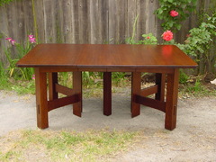Table shown open with two leaves. Measures 6' long.  When table is opened, the large center leg separates to reveal hidden center leg which supports the leaves. 